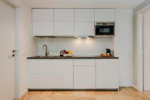 a kitchen with white cabinets and a sink at Sweett - Mazzini in Milan