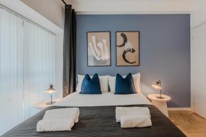 a bedroom with a large white bed with blue pillows at Sweett - Mazzini in Milan +11 photos