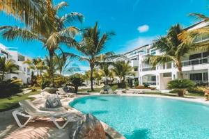 a swimming pool with palm trees and a building at Luxury Apartment IZHA 202 in La Laguna