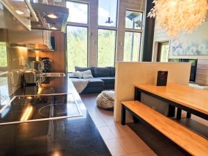 eine Küche und ein Wohnzimmer mit einem Tisch und einer Couch in der Unterkunft Villa Luoteistuuli - 8+2 hlö, Luoteis-Himos Ski-in/out, 88m² + 30m² in Jämsä + 17 Fotos