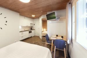 Un dormitorio con una cama y una mesa y una cocina. en Vuokatti Weekend Studio, en Vuokatti