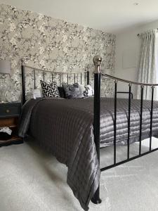 a bedroom with a large bed with floral wallpaper at Abbey Green Farm in Wem