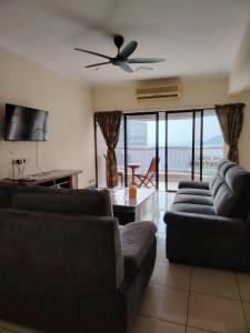 ein Wohnzimmer mit 2 Sofas und einem Deckenventilator in der Unterkunft Marina Court Kota Kinabalu in Kota Kinabalu