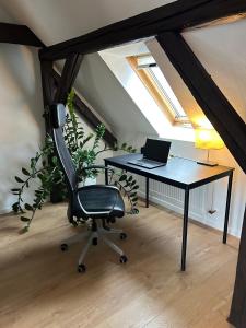 an attic office with a desk with a laptop on it at Schöne neue DG Wohnung mit sonniger Dachterrasse und fantastischem Ausblick in Naumburg