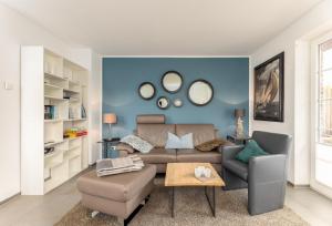 a living room with a couch and chairs and mirrors at Sonnenfreude in Westerland