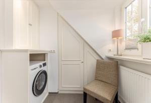 a laundry room with a washing machine and a chair at Sonnenfreude in Westerland