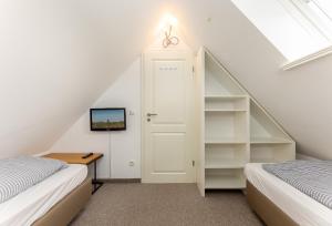 a attic bedroom with two beds and a window at Sonnenfreude in Westerland