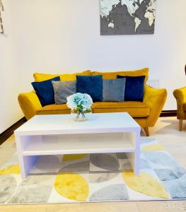 a living room with a yellow couch and a white coffee table at Fairy Meadows Hideaway in Peterborough