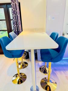 a white table with blue chairs around it at Fairy Meadows Hideaway in Peterborough