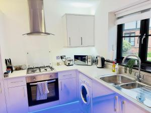 a white kitchen with a sink and a stove at Fairy Meadows Hideaway in Peterborough +8 photos