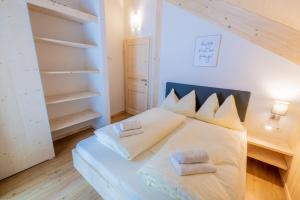 a bedroom with a large white bed with two pillows at Alpenchalet Mountain Retreat Murau in Sankt Lorenzen ob Murau