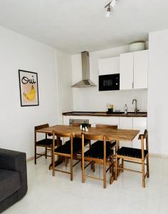 アロナにあるLas Vistas Beach By Agüita Saladaの木製のテーブルと椅子のあるキッチンとダイニングルーム