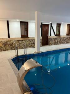 a large swimming pool with a curved object in a building at Pool & Rest Holiday Home 3D in Bihać +4 photos