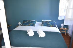 a blue bedroom with a bed with two white towels at Le colibri bleu in Argeliers