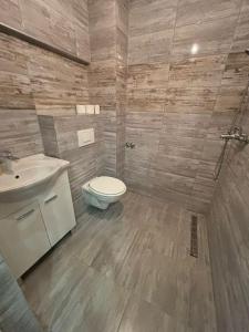 a bathroom with a toilet and a sink at Pool & Rest Holiday Home 3D in Bihać