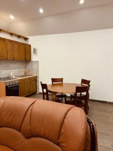 a living room with a table and chairs and a kitchen at Pool & Rest Holiday Home 3D in Bihać