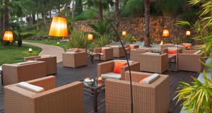 a patio with wicker chairs and tables and lamps at Precise Resort El Rompido-The Hotel in El Rompido
