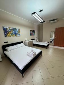 Villa Carmela - Elegante villa immersa nel verde في ماريليانو: غرفة نوم بها سرير كبير وغرفة معيشة