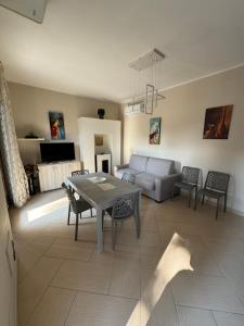 Villa Carmela - Elegante villa immersa nel verde في ماريليانو: غرفة معيشة بها طاولة وأريكة