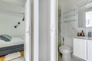 a white bathroom with a toilet and a sink at T2 à 10min de Paris l Proche des Transports in Charenton-le-Pont