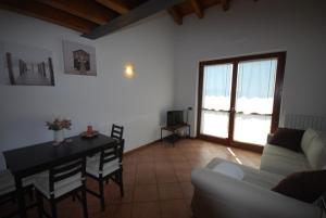 a living room with a table and a couch at Appartamento Cristina - Theater Home in Tignale
