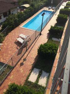 an overhead view of a swimming pool with chairs and a fence at Appartamento Cristina - Theater Home in Tignale +3 photos