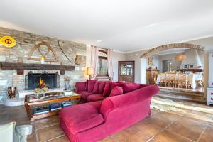 un salon avec un canapé rouge et une cheminée dans l'établissement CASCINA MONFERRATO 12, Emma Villas, à Sala Monferrato