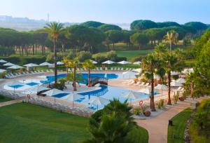 una vista aérea de una piscina del complejo con palmeras en Precise Resort El Rompido-The Hotel, en El Rompido