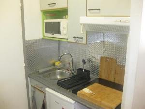 a small kitchen with a sink and a microwave at 3-7 Centre Ville in Montauban