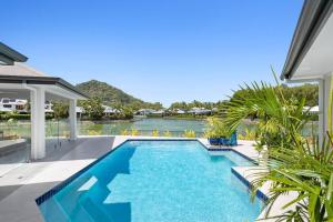 a swimming pool with a view of a body of water at Lakeside Luxury, stroll to beach & restaurants- Pets Welcome in Trinity Beach