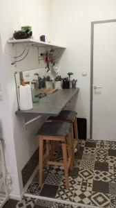 a kitchen with a counter with a table and stool at 3-7 Centre Ville in Montauban +3 photos
