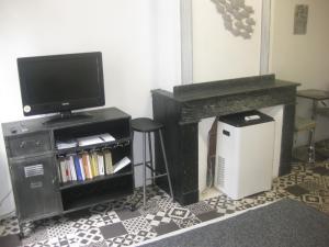a living room with a tv and a table with a stool at 3-7 Centre Ville in Montauban