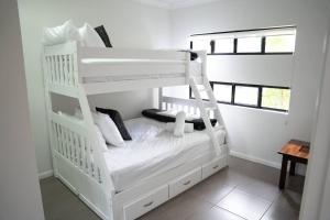 a white bunk bed with a ladder in a room at Lakeside Luxury, stroll to beach & restaurants- Pets Welcome in Trinity Beach +62 photos