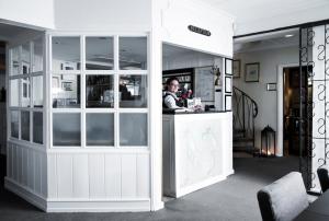 a man sitting at a counter in a restaurant at Skjalm Hvide Hotel in Slangerup