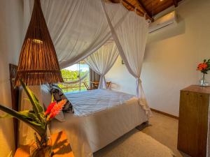 a bedroom with a canopy bed with a window at Casa do Alto Residence in Porto Seguro +14 photos