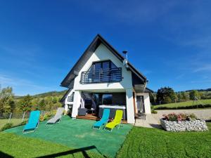 a house with chairs on a lawn at Chałpy Na Wierchu in Rzepiska