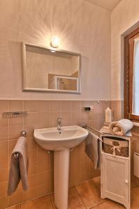 un baño con lavabo y espejo en Appartamento Il Gufo - Theater Home, en Tignale