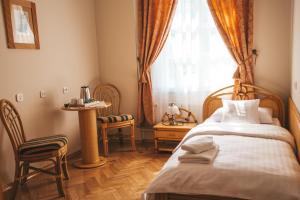 a bedroom with a bed and a window and chairs at Pałac Sieniawa in Sieniawa