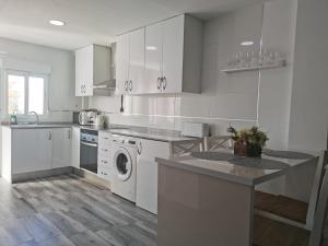a kitchen with white cabinets and a washer and dryer at Plaza Sainetero in Valencia