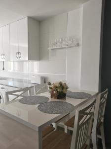 a kitchen with white cabinets and a table and chairs at Plaza Sainetero in Valencia +16 photos