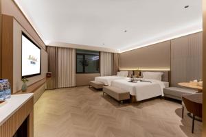 una camera d'albergo con un letto e una televisione di Merlinhood Hotel Xi'an Bell and Drum Tower Changlemen Subway Station a Xi'an