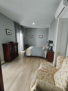 una camera da letto con un letto e un divano di casa la zarzamora a Jerez de la Frontera