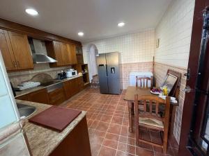 a kitchen with a table and a refrigerator at La Casona de Piedra in Cartagena