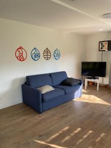 a blue couch in a living room with a tv at Bigge Elements Gästezimmer 4 "Westen" 4 Personen in Olpe