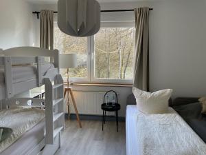 a bedroom with two bunk beds and a window at Bigge Elements Gästezimmer 4 "Westen" 4 Personen in Olpe