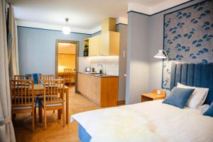 a bedroom with a bed and a table and a kitchen at Livonia Central Apartments in Valga
