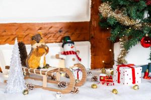 a figurine of a bird on a sled next to a christmas tree at Refuge des Vignerons - Turckheim in Turckheim