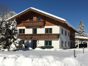 a house in the winter with snow on the ground at Landhaus Schwentner in Kössen