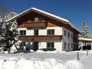 dom w zimie z śniegiem na ziemi w obiekcie Landhaus Schwentner w mieście Kössen