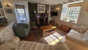 un soggiorno con divano e camino di Cove Cottage a Portloe